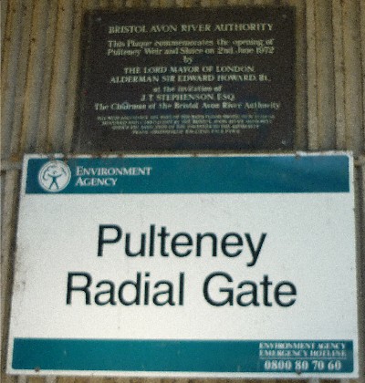 Plaque on flood control gate structure